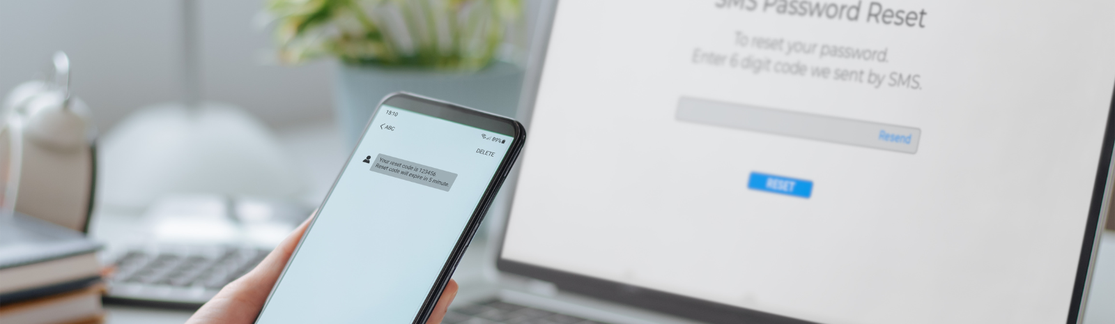 person receiving a verification code on mobile device to reset password on labtop